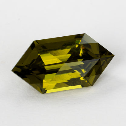 Yellow-green lab-grown sapphire at a shallow crown angle, with long bright yellow facet reflections.