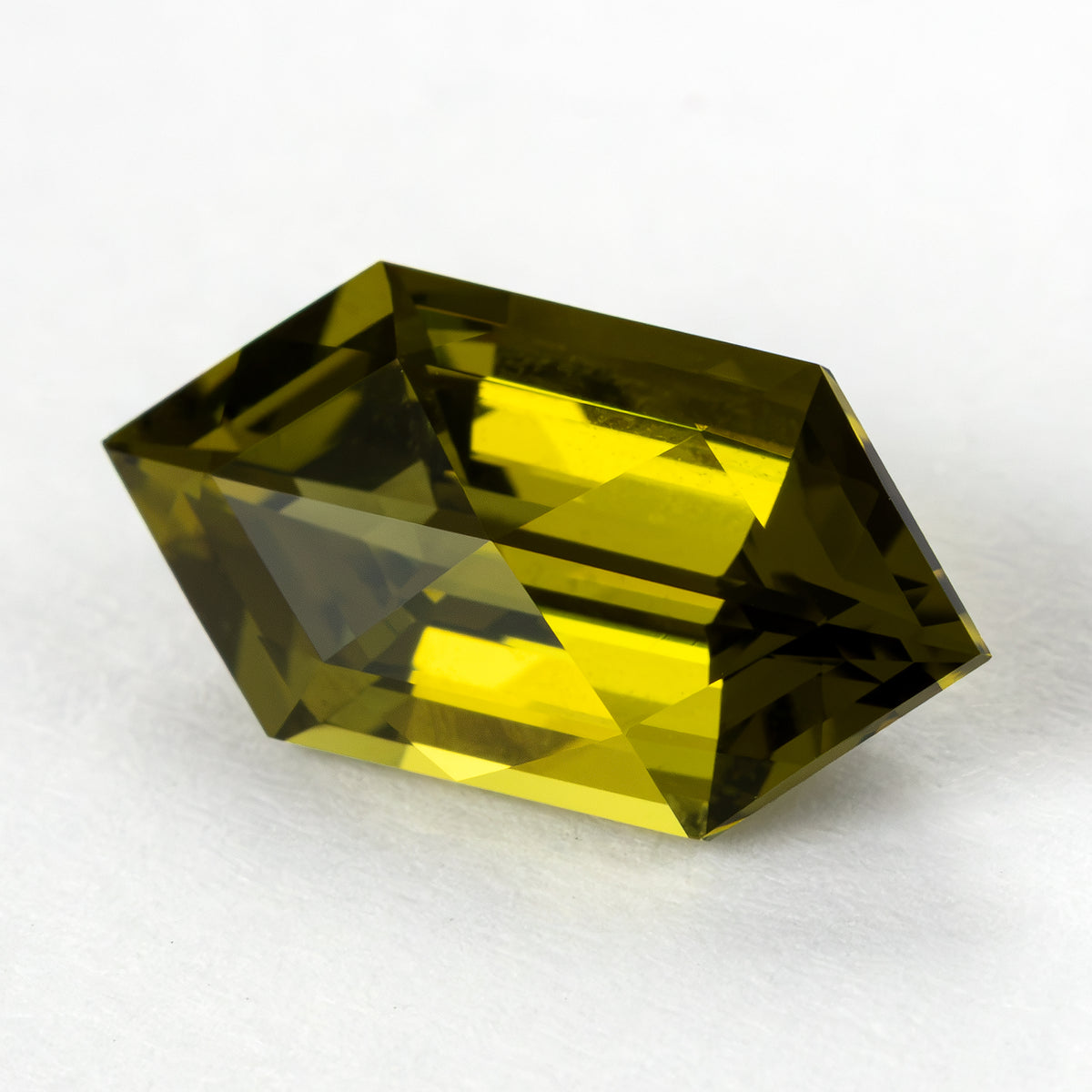 Yellow-green lab-grown sapphire tilted in the opposite direction, revealing a different crown reflection pattern.