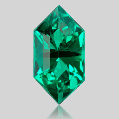 Face-up green lab-grown emerald standing vertically, with an elongated six-sided outline and reflection below.
