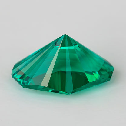 Side and pavilion profile of the green emerald, showing its pointed underside and depth.