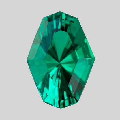 Alternate upright view of the green emerald on white, showing angular central reflections.