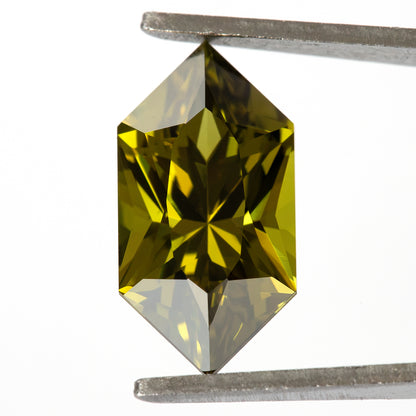 Face-up sapphire in tweezers showing alternating yellow-green and dark geometric facets.