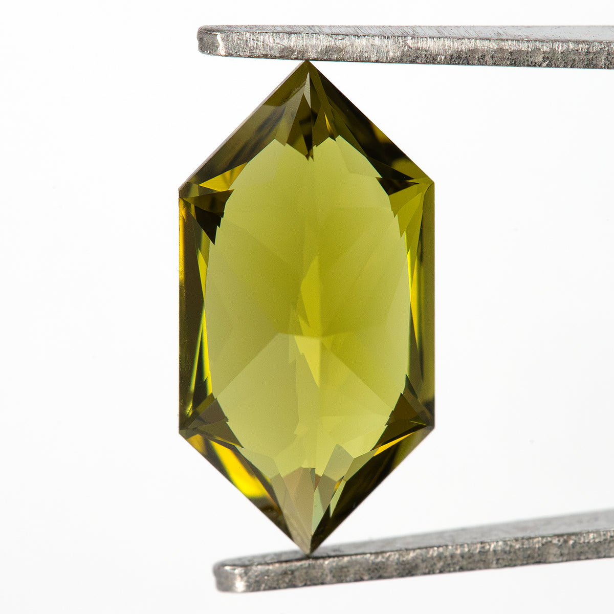 Rear pavilion view of the lab-grown sapphire held between tweezers.