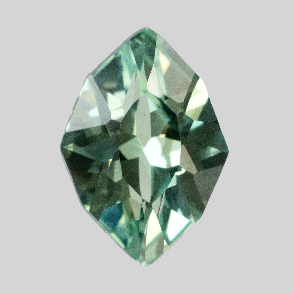 Vertical crown view of the green lab-grown sapphire against a light gray background.