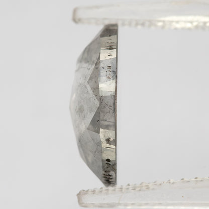 Edge-on profile of the oval diamond held in pale tweezers, showing crown height and girdle.