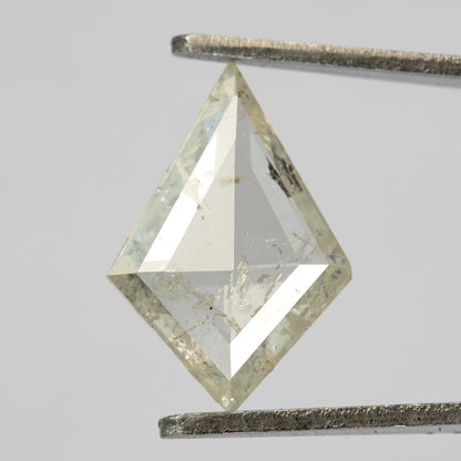 Kite-shaped pale gray diamond held upright in metal tweezers, with broad triangular facets and visible inclusions.