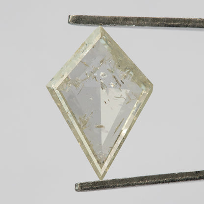Reverse view of the kite diamond in tweezers, with a flatter central area and visible inclusions.