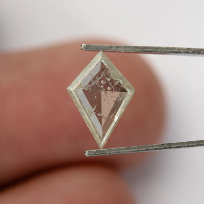 Reverse of the kite diamond against a fingertip, showing inclusions through the central area.