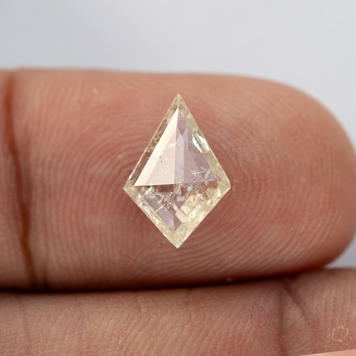 A second fingertip view of the kite diamond, showing changing facet reflections.