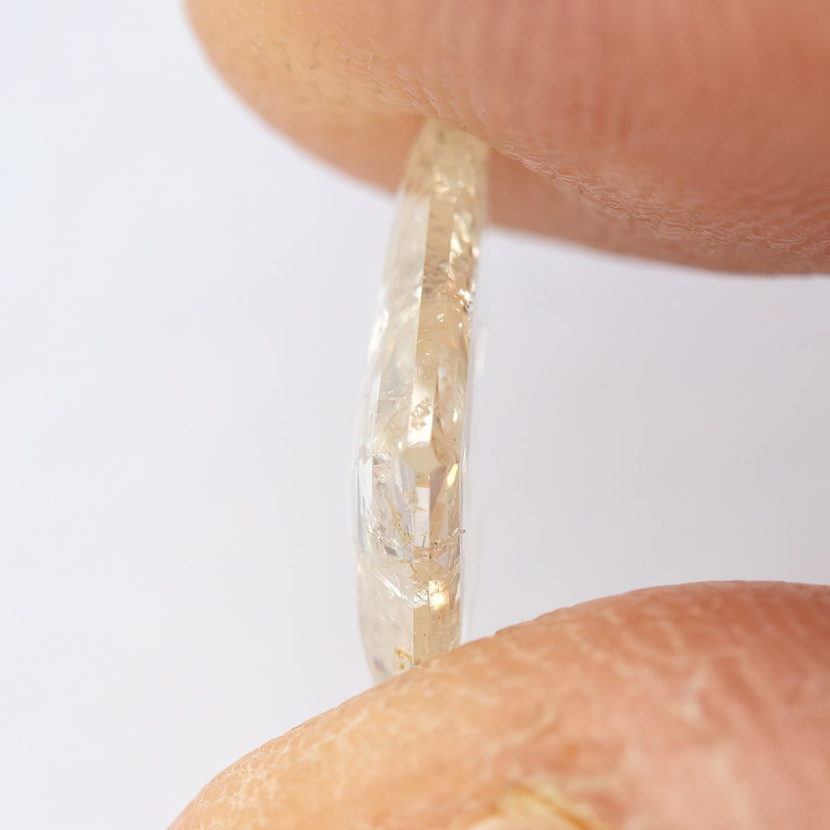 Thin edge-on profile of the kite diamond held between fingertips.