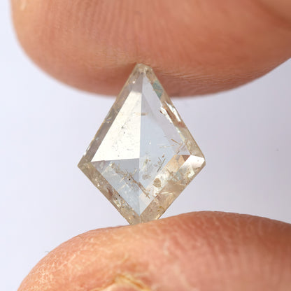 Tilted kite diamond between fingertips, showing a different reflection through the crown.