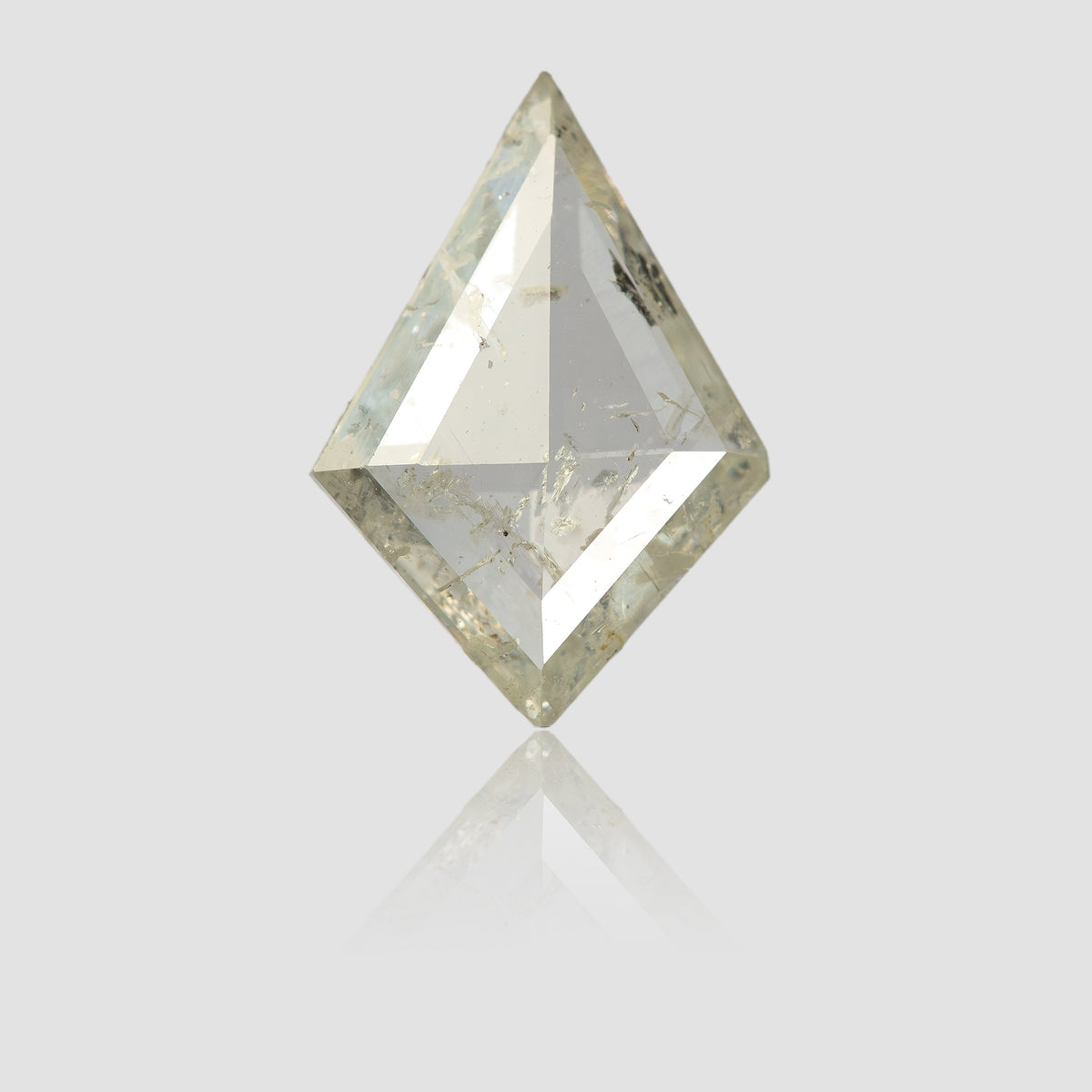 Upright kite diamond on a reflective pale surface, with a faint reflection beneath it.