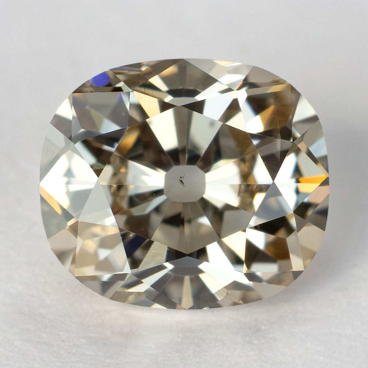 Face-up view of the 0.64 ct Old Mine Cut natural diamond, showing its facet pattern and large culet on a light background.