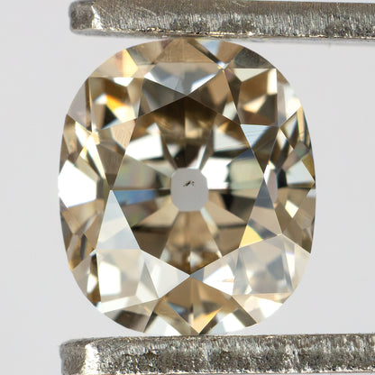 Close-up face-up view of the Old Mine Cut natural diamond held in metal tweezers, showing its facet arrangement.