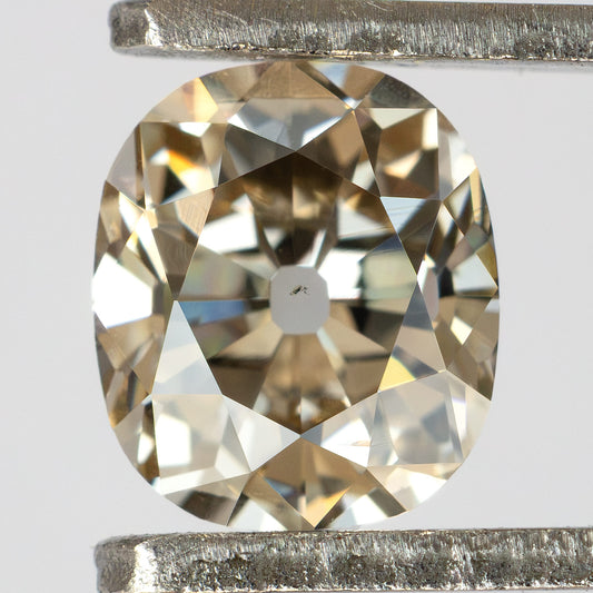 Close-up face-up view of the Old Mine Cut natural diamond held in metal tweezers, showing its facet arrangement.