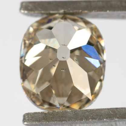 Reverse view of the diamond held in tweezers, showing the pavilion facets and large culet.