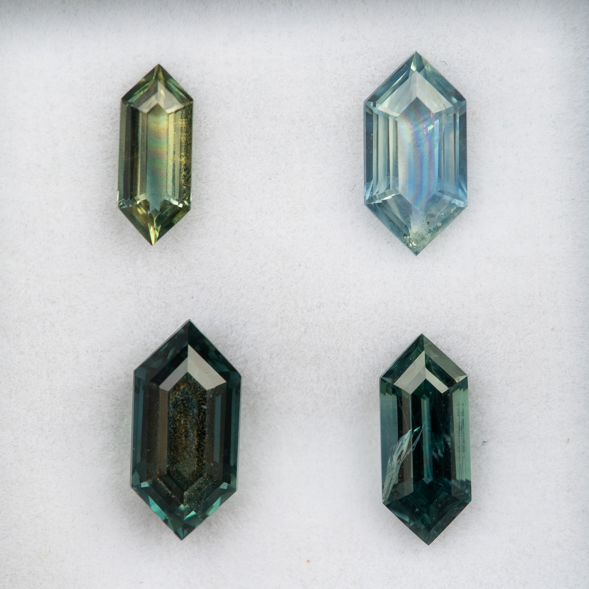 All four numbered-style natural sapphires arranged together for face-up comparison.