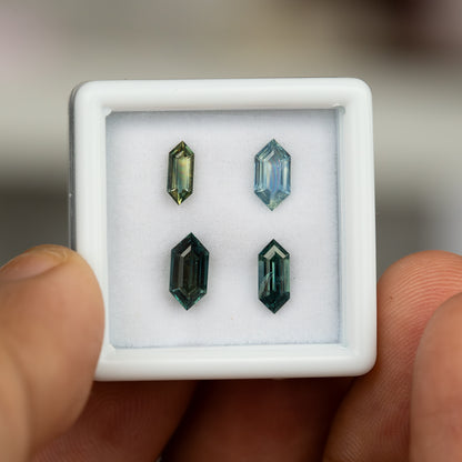 Four natural sapphires displayed together in a gemstone box.