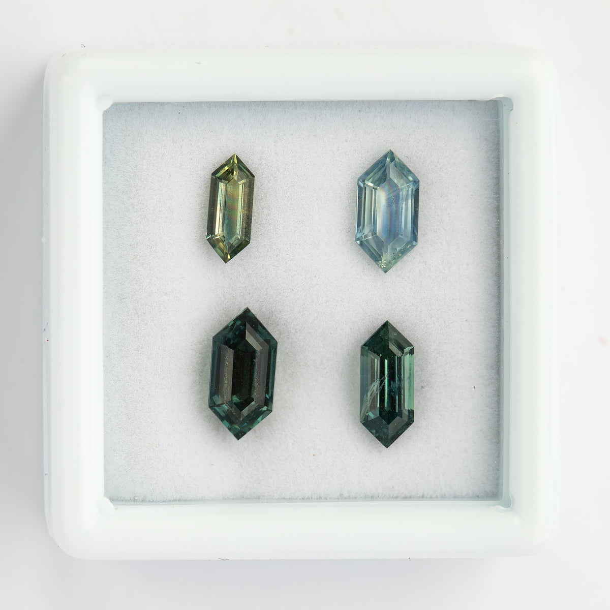 Close group view of four Dutch marquise natural sapphires under daylight.