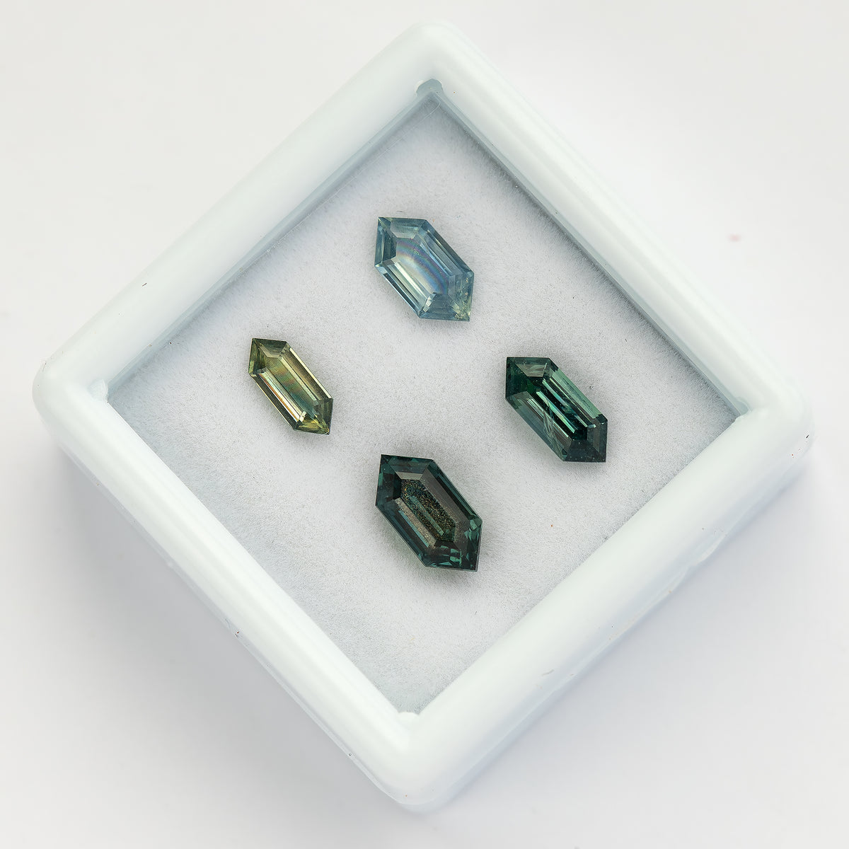 Angled group view showing facets and proportions across the four sapphires.