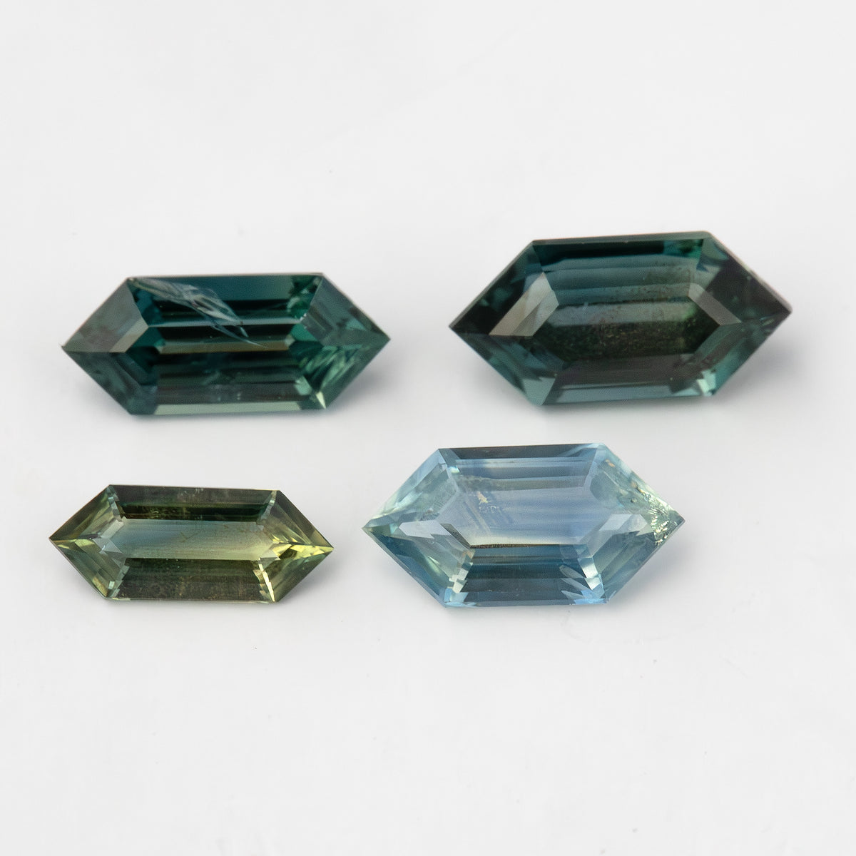 Group view of the four elongated hexagon sapphires showing their color range.