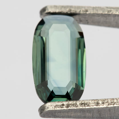 Broad-face tweezers view showing a pale central reflection and dark green border facets.