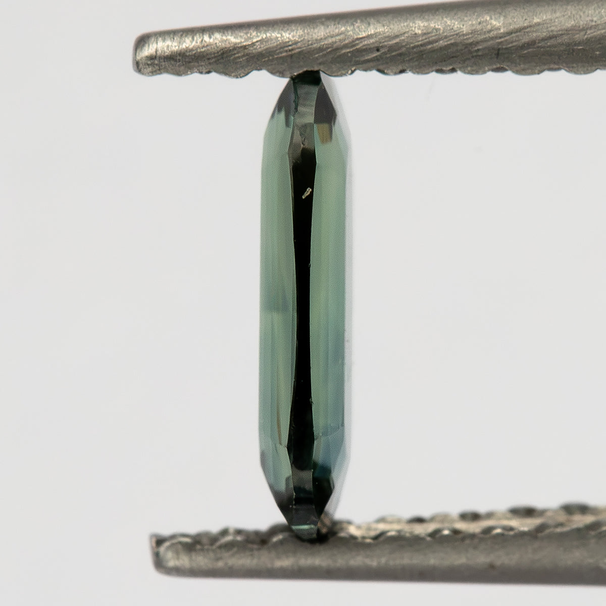 Edge-on tweezers view showing the sapphire’s very shallow side profile.