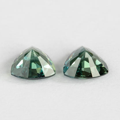 Low side view of the sapphire pair showing pavilion profiles and the different depths of the two loose stones.