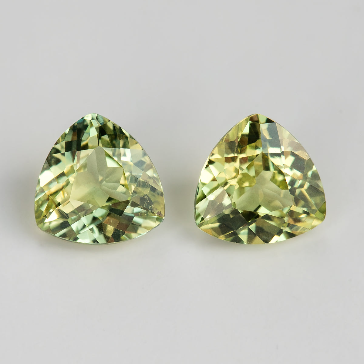 Close face-up macro of the sapphire pair, showing the facets, reflections and visible internal characteristics of each loose stone.