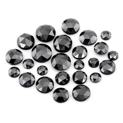 Group of black round rose-cut diamonds of mixed sizes on a white background, showing triangular crown facets.