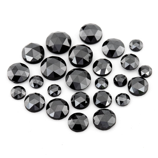 Group of black round rose-cut diamonds of mixed sizes on a white background, showing triangular crown facets.