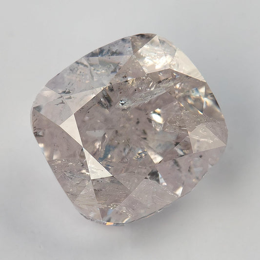 Face-up macro of the exact 1.02 ct natural light pink cushion diamond, showing visible inclusions and its soft square outline.