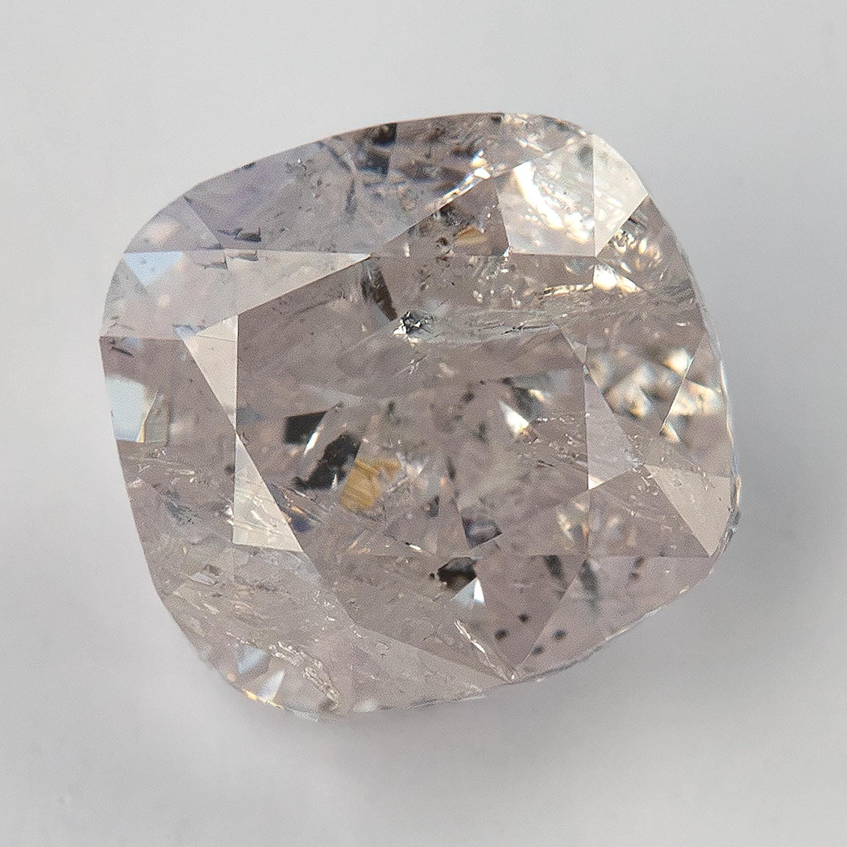 Alternate face-up macro of the natural light pink cushion diamond with heavy inclusions and modified brilliant facets.