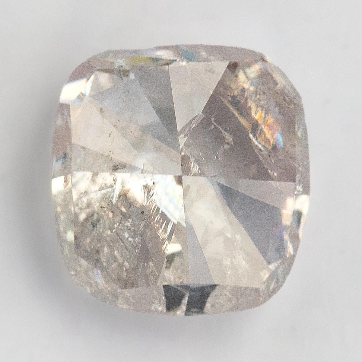 Three-quarter view of the 1.02 ct cushion diamond showing its pale pink appearance, depth and inclusions.
