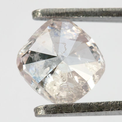 Pavilion view of the natural light pink cushion diamond held in tweezers, showing modified brilliant facets.