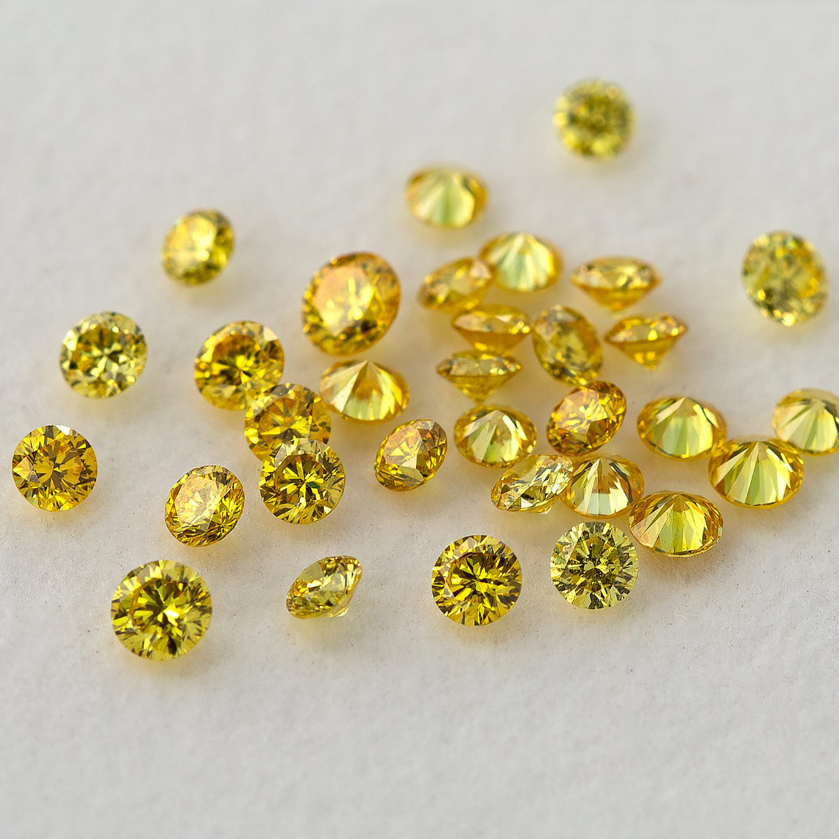 Loose yellow diamonds viewed from above with a mixture of face-up and tilted positions.