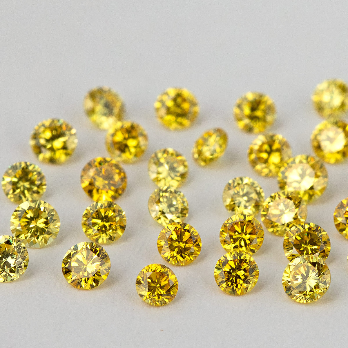 Low face-up angle across yellow round diamonds, with the nearest facets in focus.