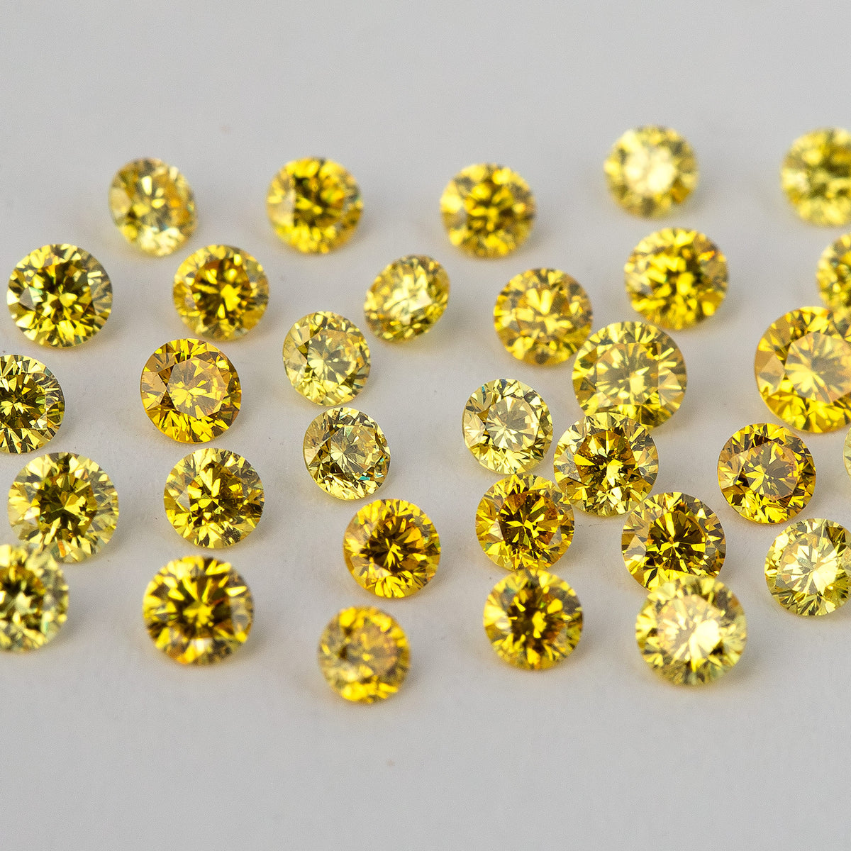 Face-up yellow diamond cluster showing varied reflection patterns and yellow tones.