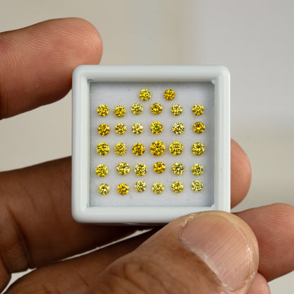 Yellow diamonds in a white tray held between a finger and thumb.