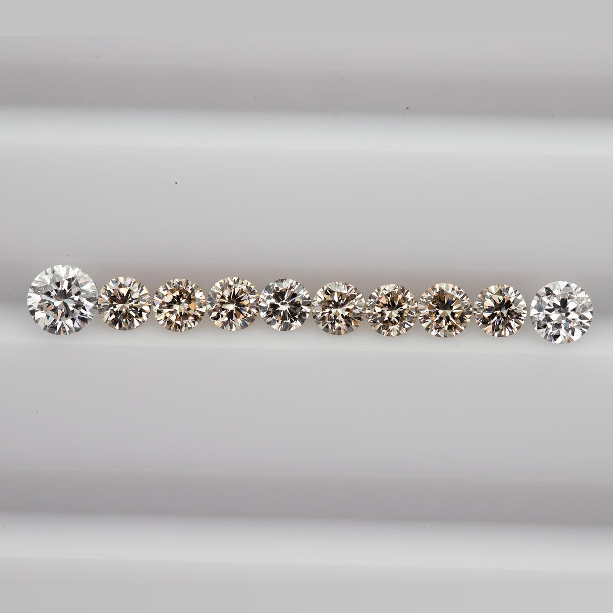 Straight row of representative 2.5mm round champagne diamonds showing calibrated diameter and sparkle.