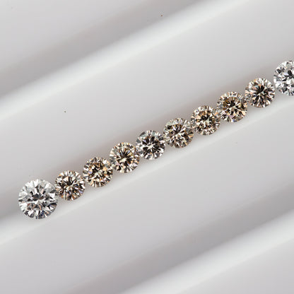 Diagonal row of representative 2.5mm champagne round diamonds with white comparison stones not included.