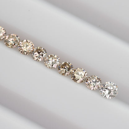 Close row of representative 2.5mm champagne diamond melee showing warm light-brown color variation.