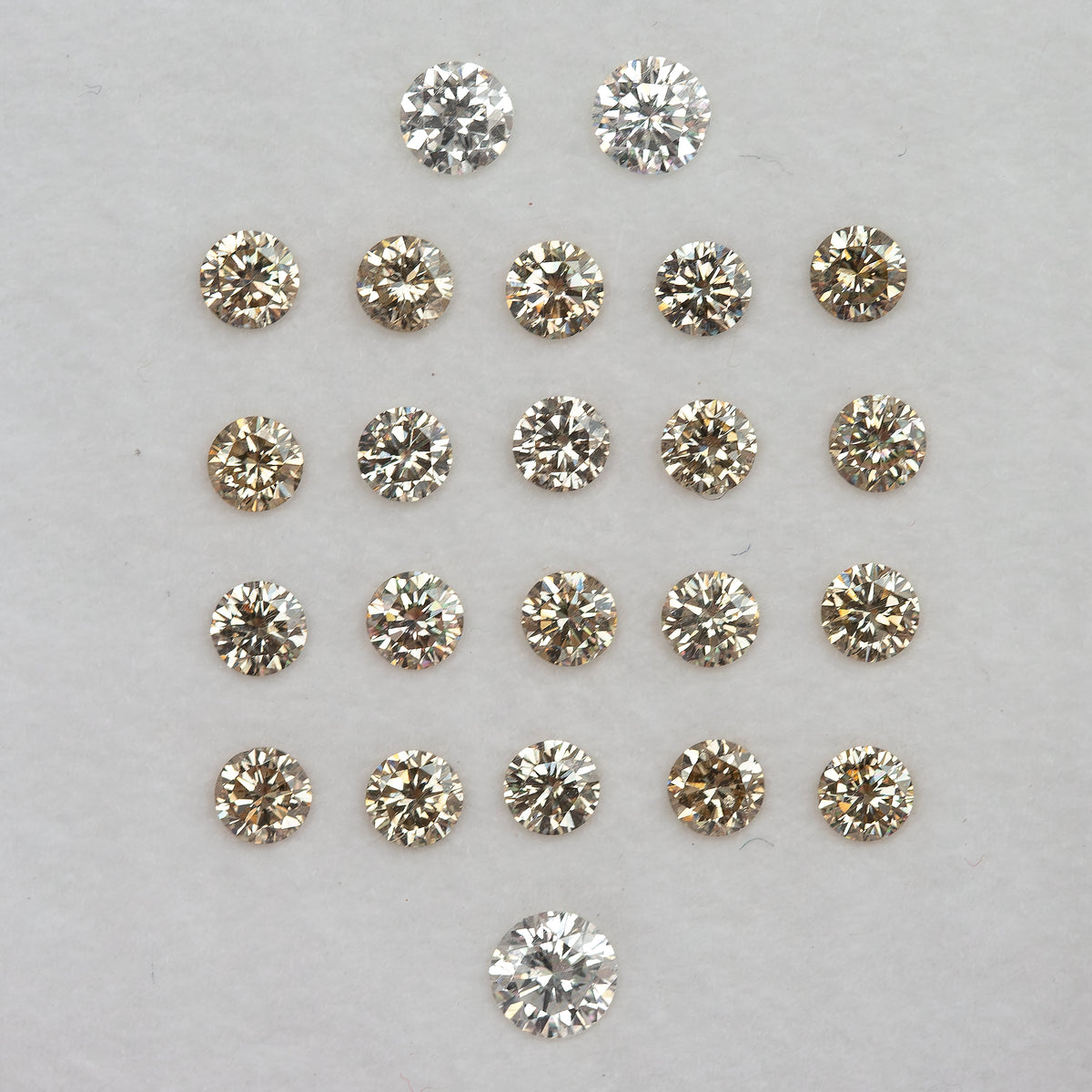 Representative champagne diamond melee arranged on a pale tray; selected pack only is supplied.