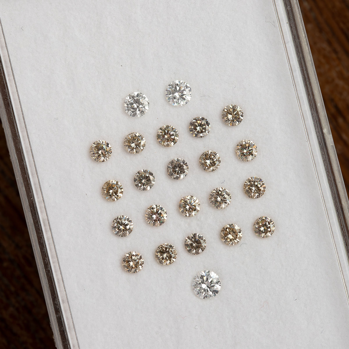 Hand-held parcel box of representative 2.5mm champagne round diamonds shown for scale.