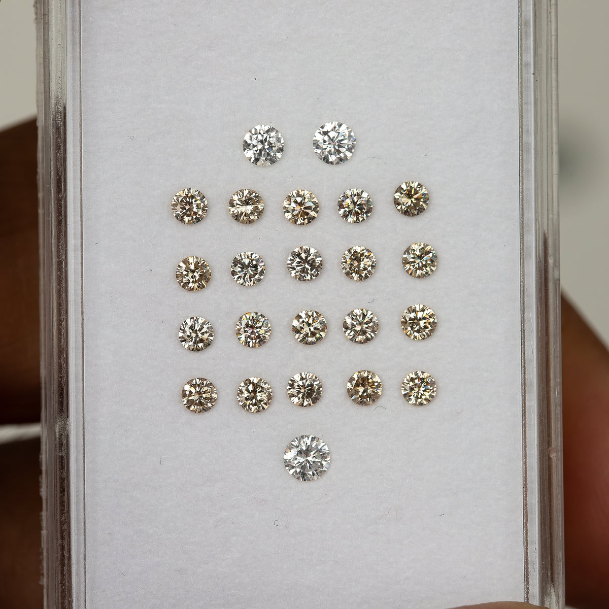 Representative 2.5mm champagne diamond melee in a parcel box under daylight.