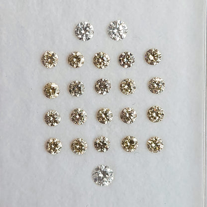 Close view of representative 2.5mm champagne diamond melee in a clear parcel box.