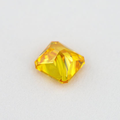 Pavilion and back view of the orange-yellow diamond, showing broad rear facets and its cut-cornered outline.