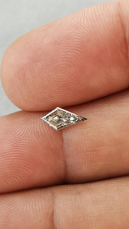 Exact elongated kite lab-grown diamond resting across fingertips to show its 9.47 x 4.58 mm scale and pointed outline.