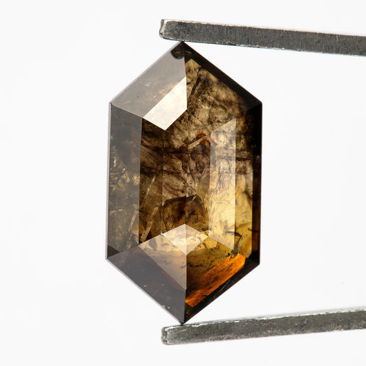 Close-up of the exact 1.15 ct natural dark brown Dutch marquise diamond in tweezers, showing its elongated outline, angular facets and visible inclusions.