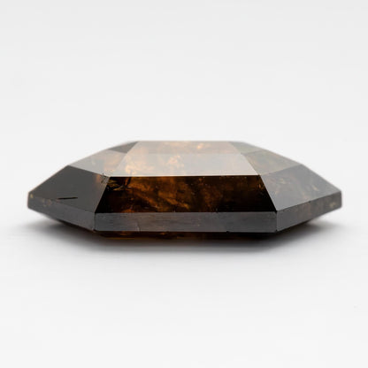 Side profile of the double-sided faceted natural diamond, showing its shallow profile and faceting across both broad faces.